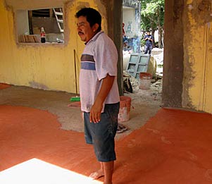 Graciano checking the new terracotta concrete floor at the Xcalacoop Child Care Center new classroom